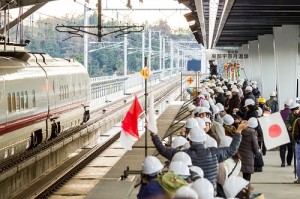 試験列車をホームで待つ人々